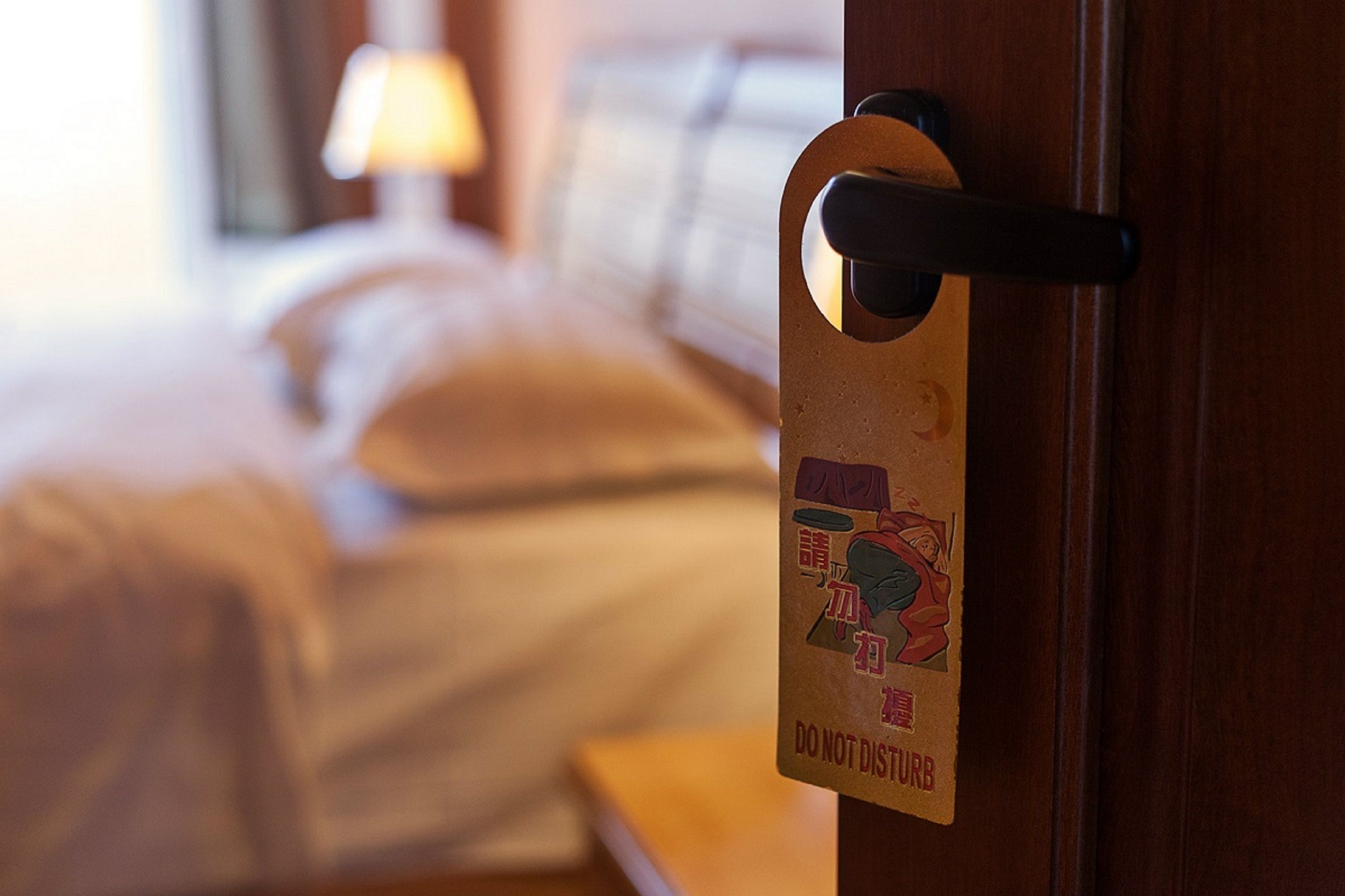 A hotel room door with a 'Do Not Disturb' sign.