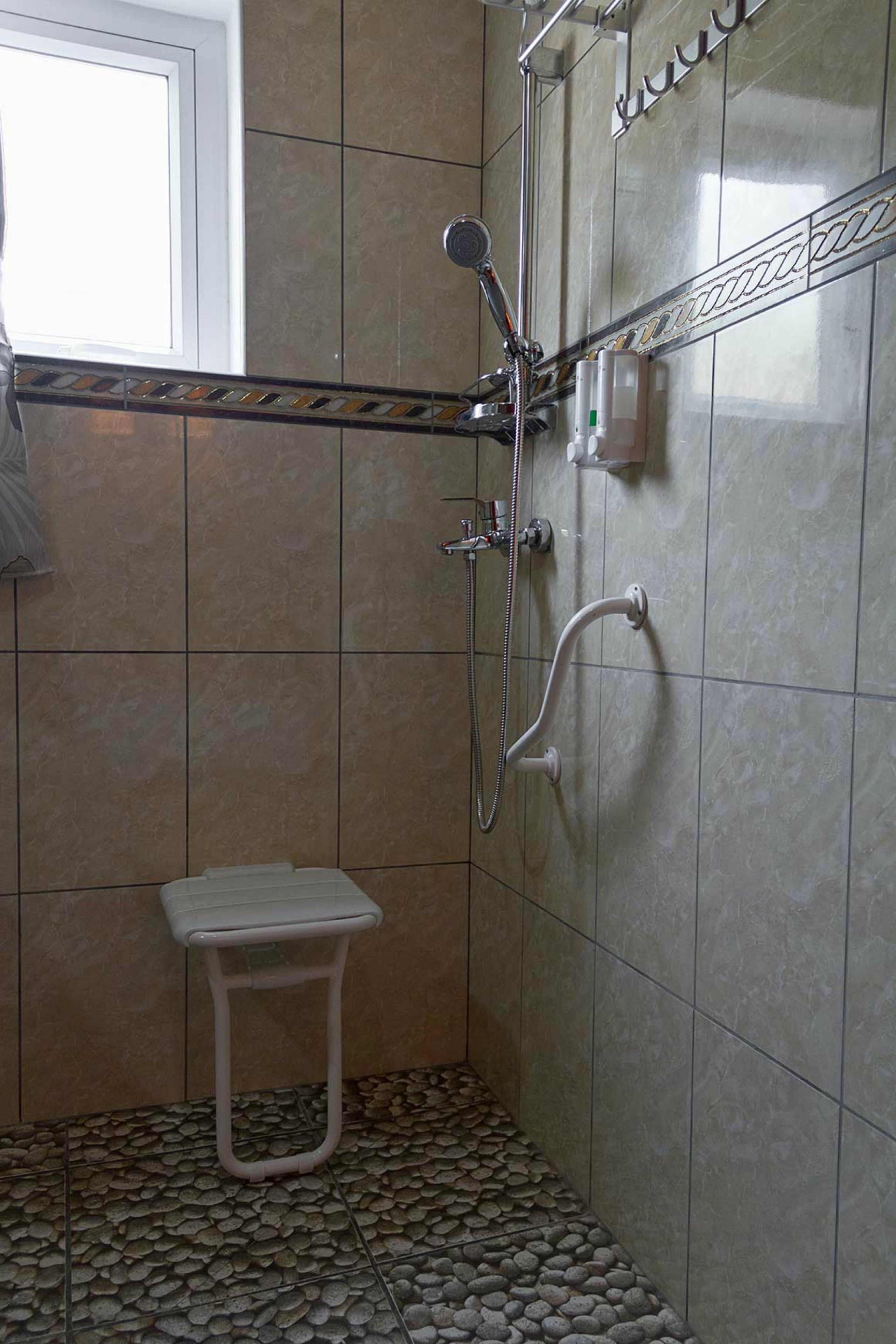 Un baño pequeño con ducha, inodoro y ventana.