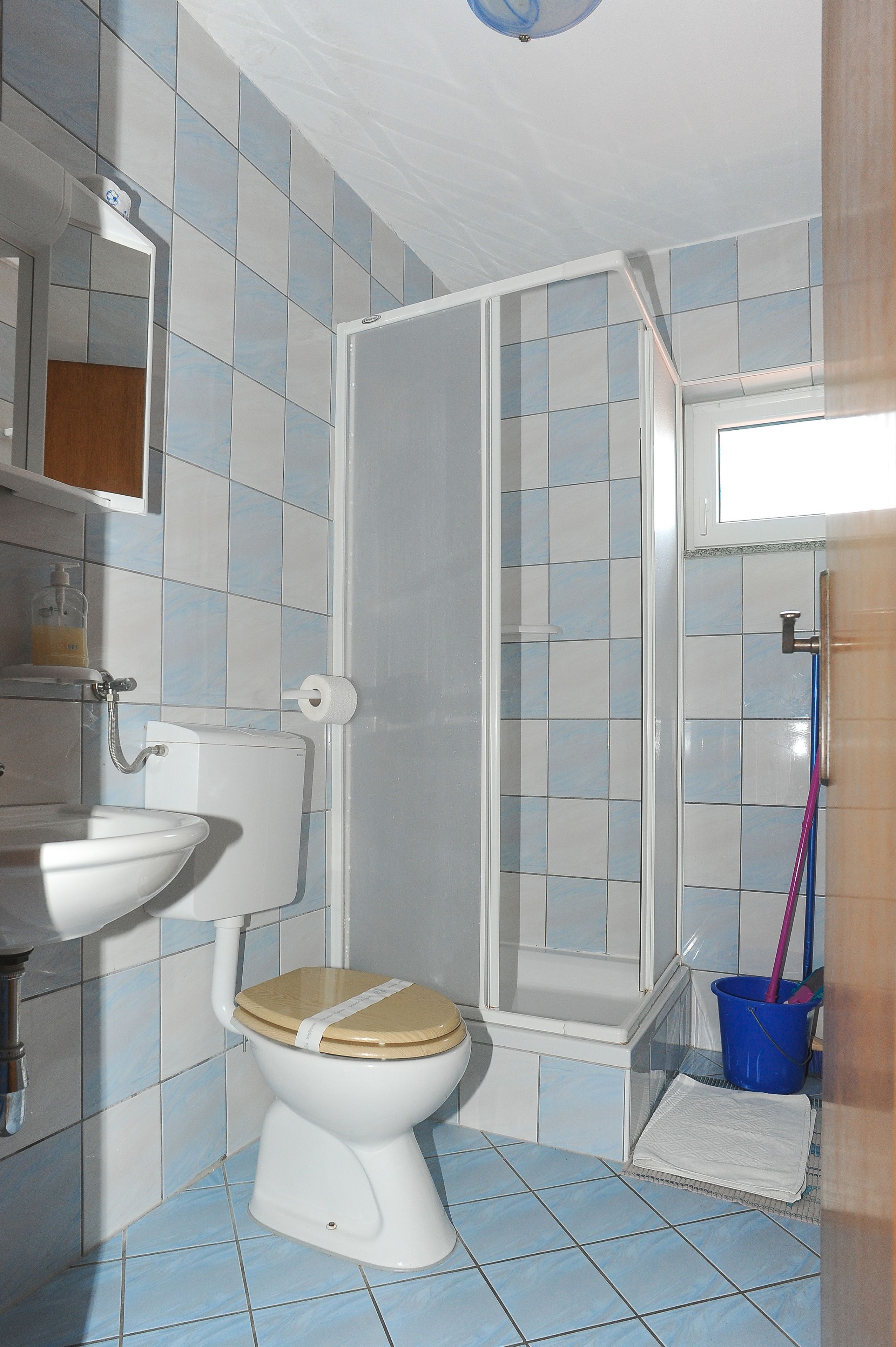 A bathroom with a toilet, sink, and shower area.