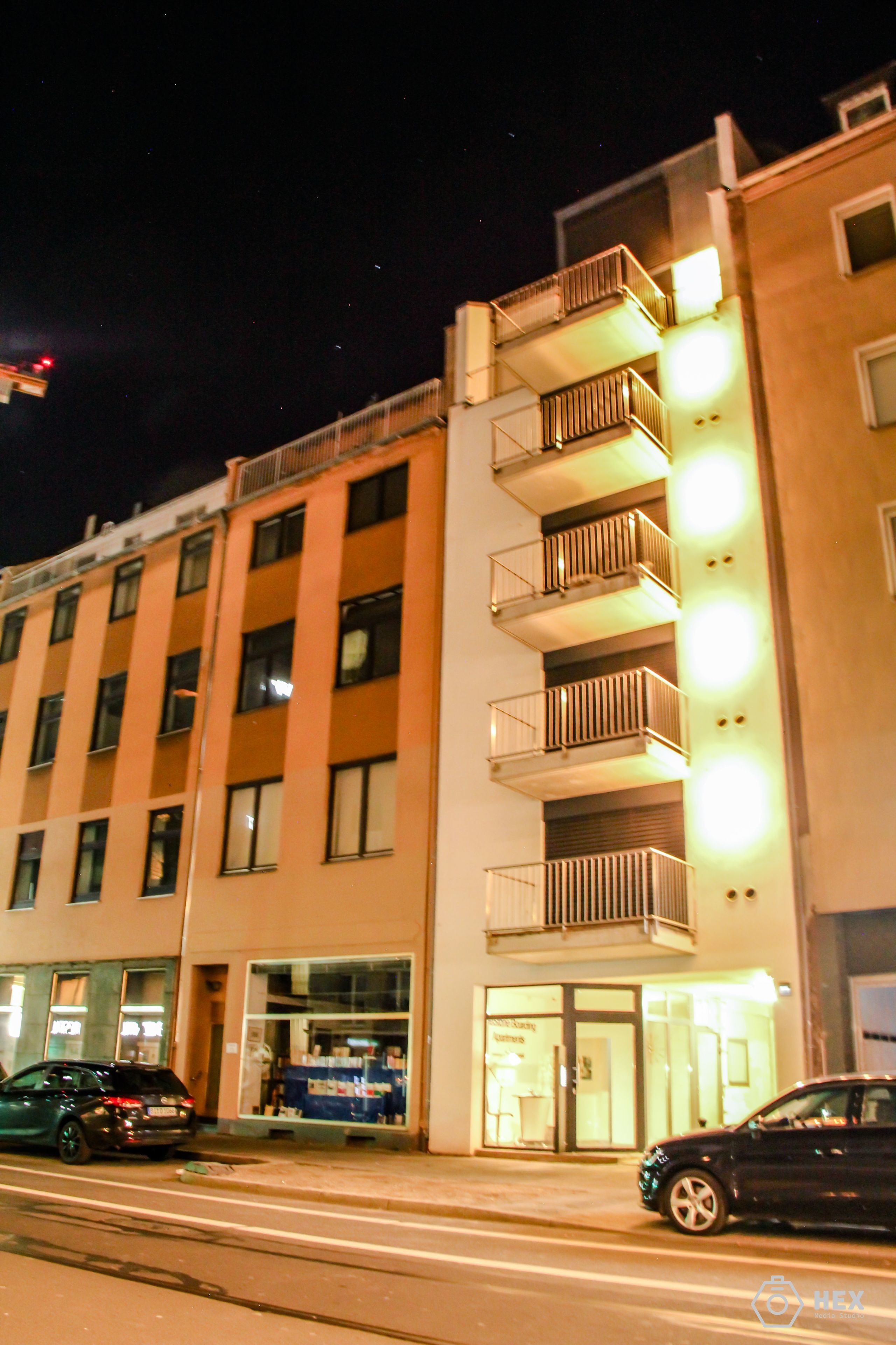 Ein mehrstöckiges Hotel mit Balkonen, einem Eingang im Erdgeschoss und einer sichtbaren Schaufensterfront.