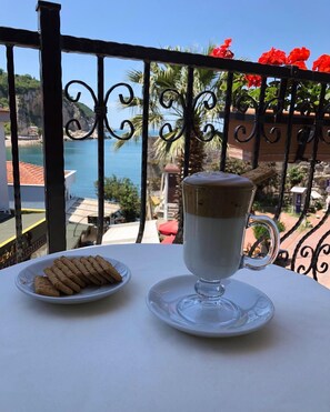 Un tavolo con una tazza di caffè e un piatto di biscotti, con vista panoramica sulla costa.