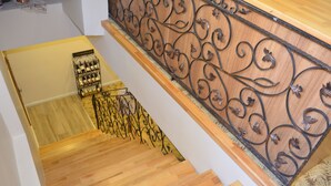 Una escalera de madera con barandilla de metal y diseños ornamentales.