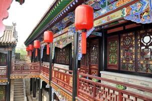 A traditional Chinese building with ornate decorations, red lanterns, and intricate woodwork.