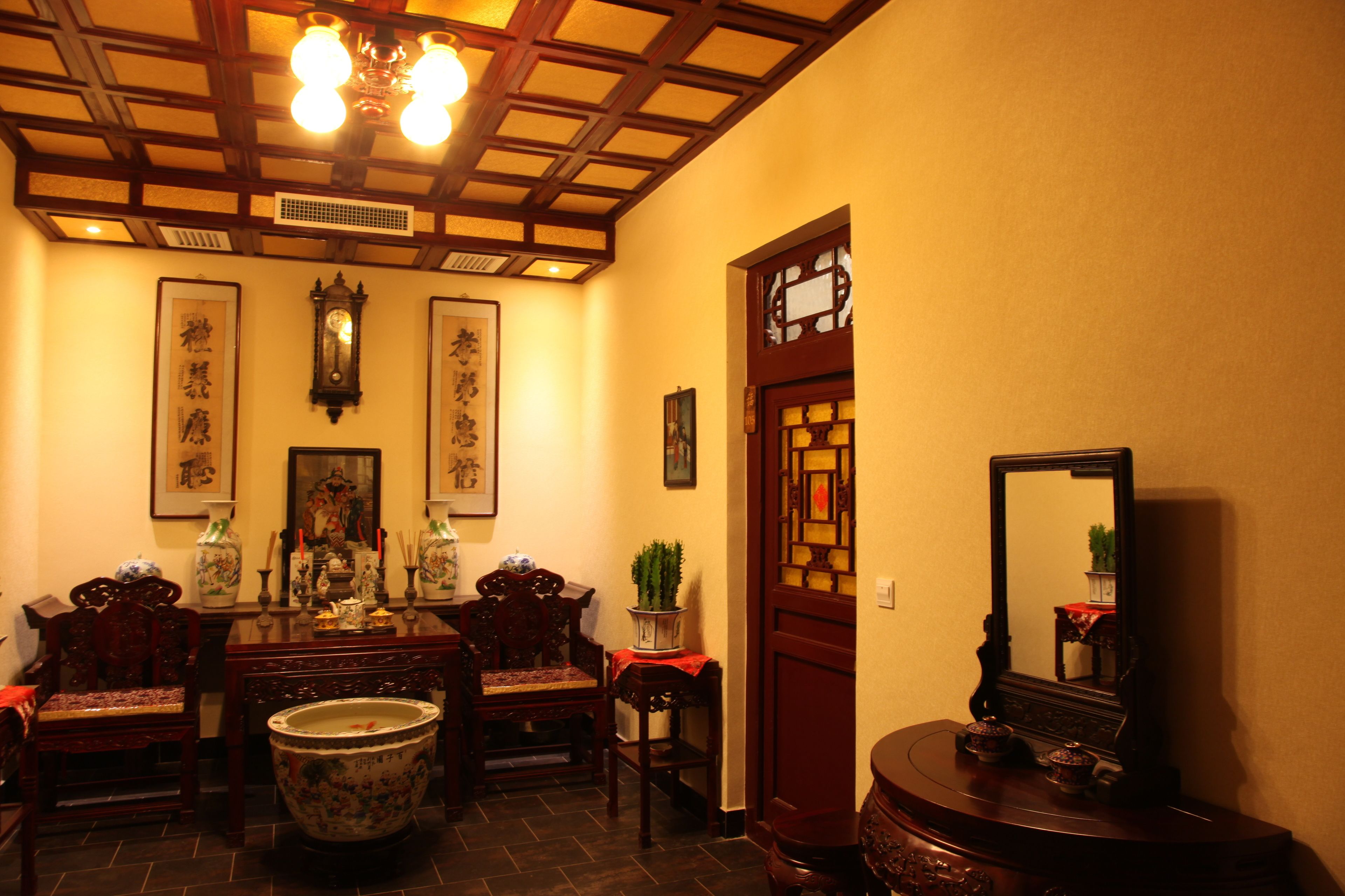 Un interior tradicional con techo de madera, un lavabo de cerámica grande y un espejo sobre un soporte de madera.