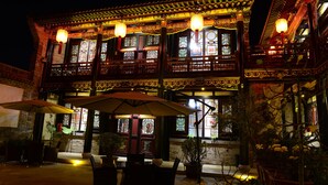 A traditional building with ornate architecture, large windows, and outdoor seating with umbrellas. - Cheng Shi Ge Hotel (Jinzhong)