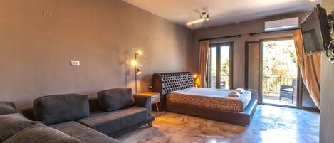 A modern bedroom with a sofa, a bed, and a balcony.