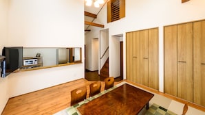 Un comedor con una mesa y sillas de madera, un espejo y armarios de madera.