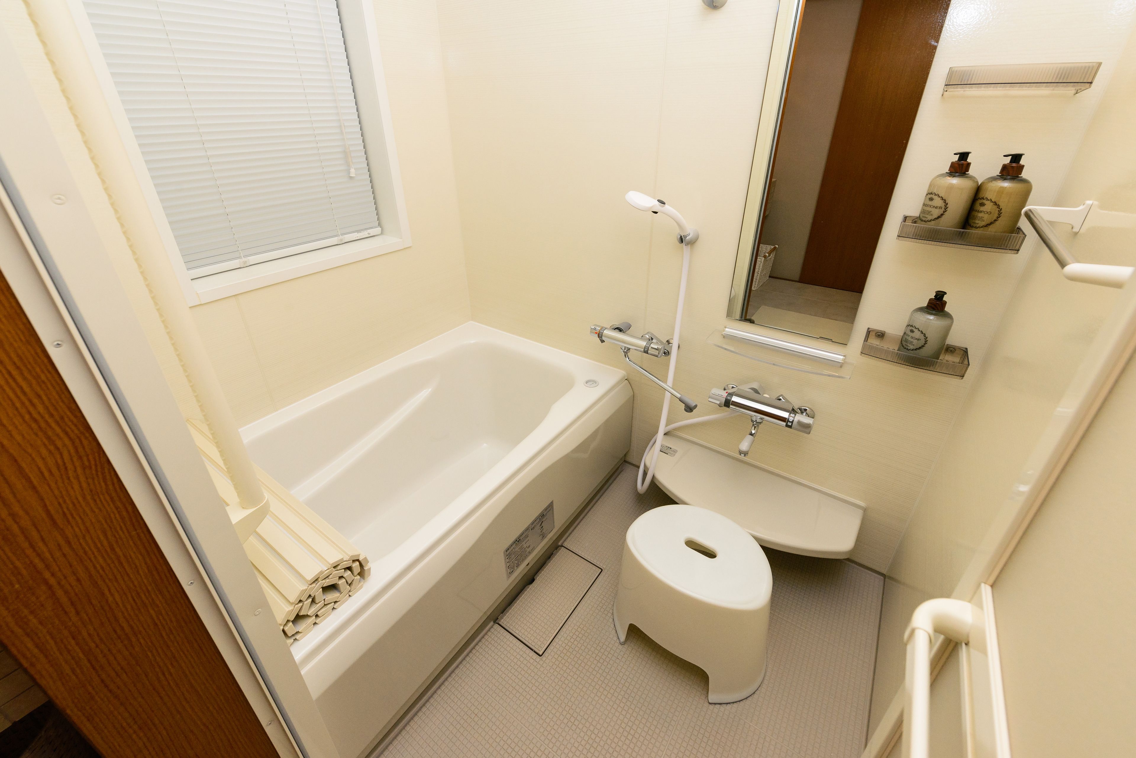A bathroom with a bathtub, toilet, sink, and a mirror.