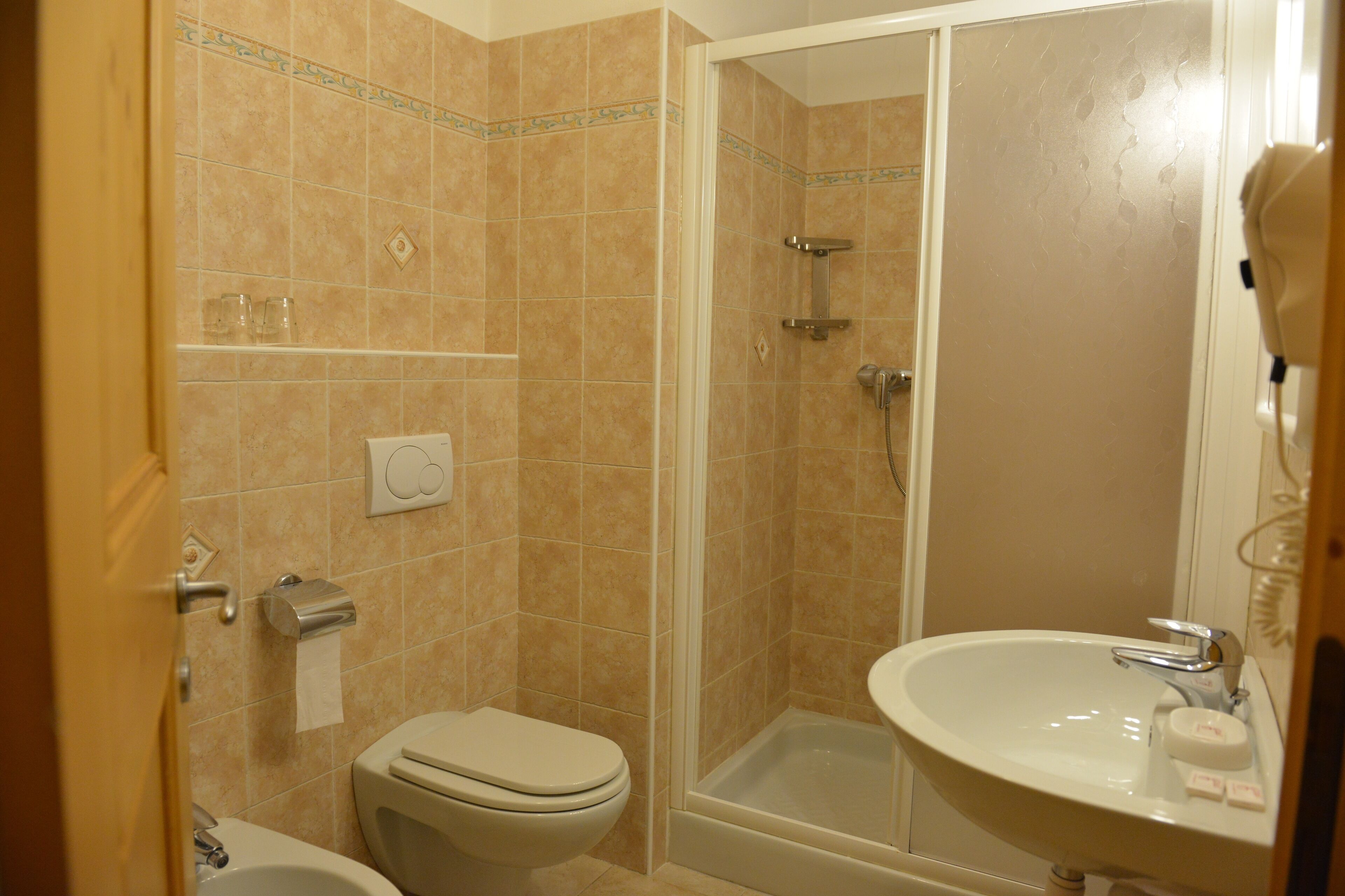 Un baño con inodoro, lavabo y ducha.