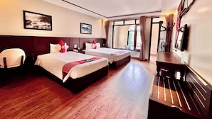 A hotel room with two beds, a desk, a chair, and a large window with curtains. - Sapa Centre Hotel (Sa Pa)
