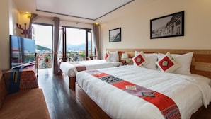 A hotel room with two beds, a TV, and a balcony with a view of the mountains. - Sapa Centre Hotel (Sa Pa)