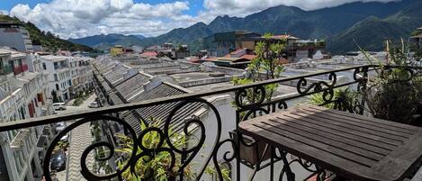 Un balcon avec vue sur la ville et les montagnes.