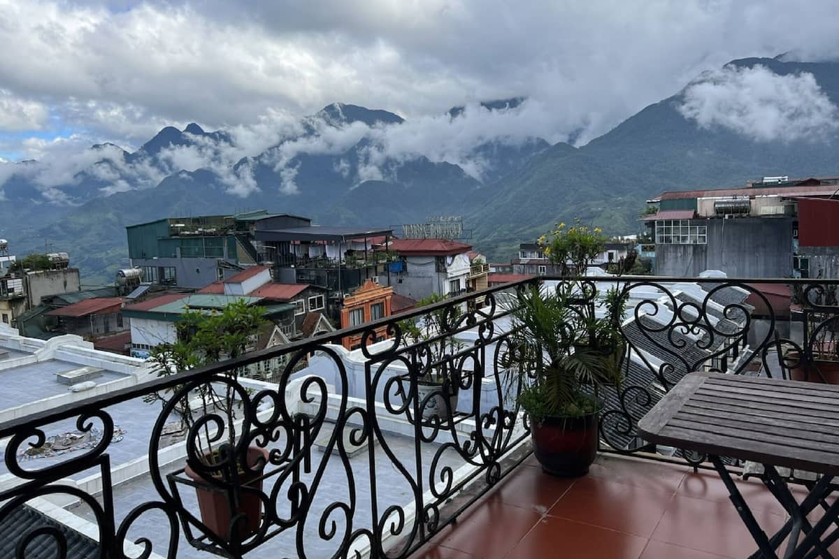 Un balcón con vistas a montañas y nubes.