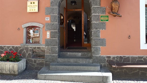 A stone archway entrance to Hotel Albergos, with a sign indicating a 4-star rating. - Albergo Gufo Depandance (Bormio)