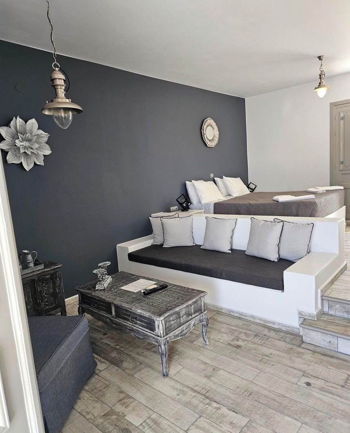 A modern living room with a grey sofa, a coffee table, and a staircase leading to an upper level.