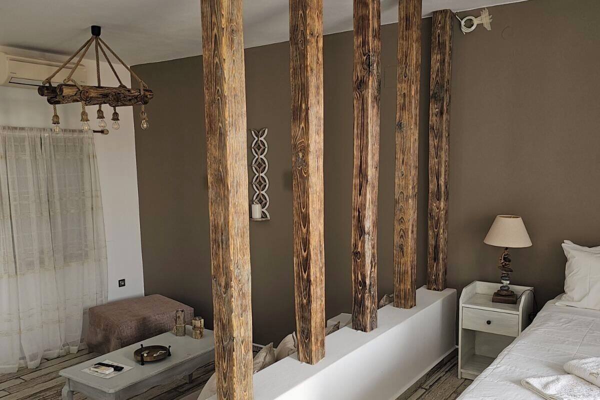 Une chambre d’hôtel moderne avec un grand lit, un petit coin salon et un panneau décoratif en bois.
