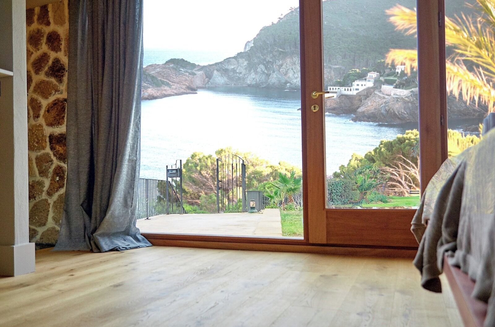 Quarto com uma grande porta de vidro deslizante que dá para uma vista costeira deslumbrante.