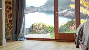 Quarto com uma grande porta de vidro deslizante que dá para uma vista costeira deslumbrante.