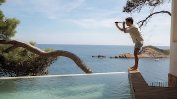 2 piscines a l'aire lliure, piscina de vora infinita i para-sols