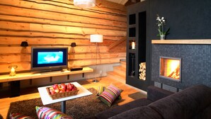 Una sala de estar moderna con una pared de madera, una chimenea, un televisor y un sofá.