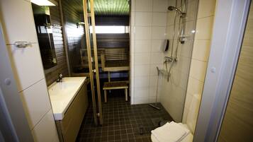 Un baño pequeño con lavamanos, inodoro y ducha.