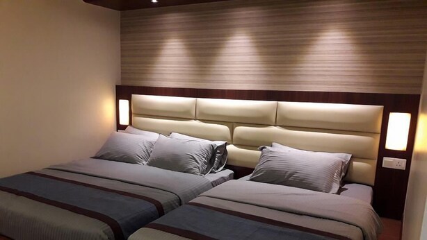 A double bed with a headboard and two bedside tables, each with a lamp. - De Benz Inn (Malacca City)