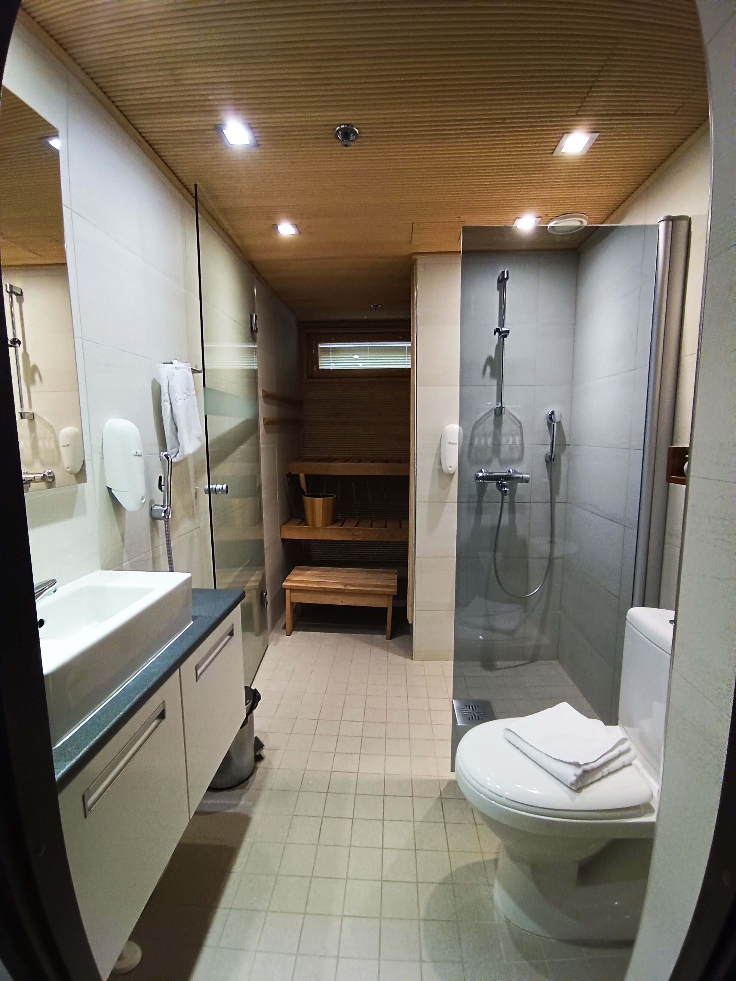 Une petite salle de bain comprenant une douche, des toilettes et un lavabo.
