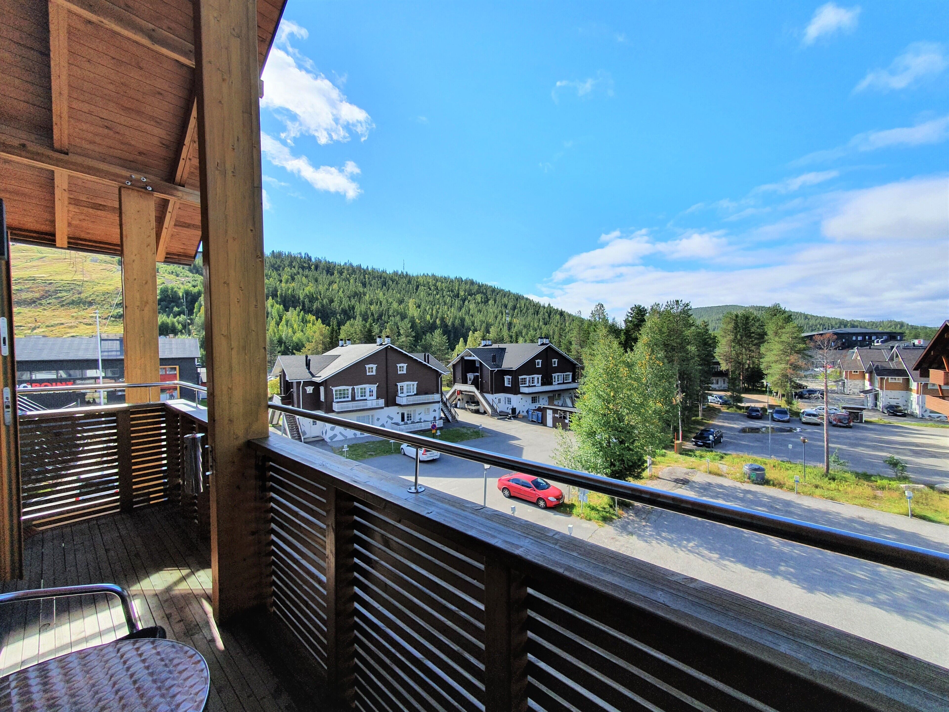 Un balcon donnant sur un quartier résidentiel, avec vue sur des maisons et une route.
