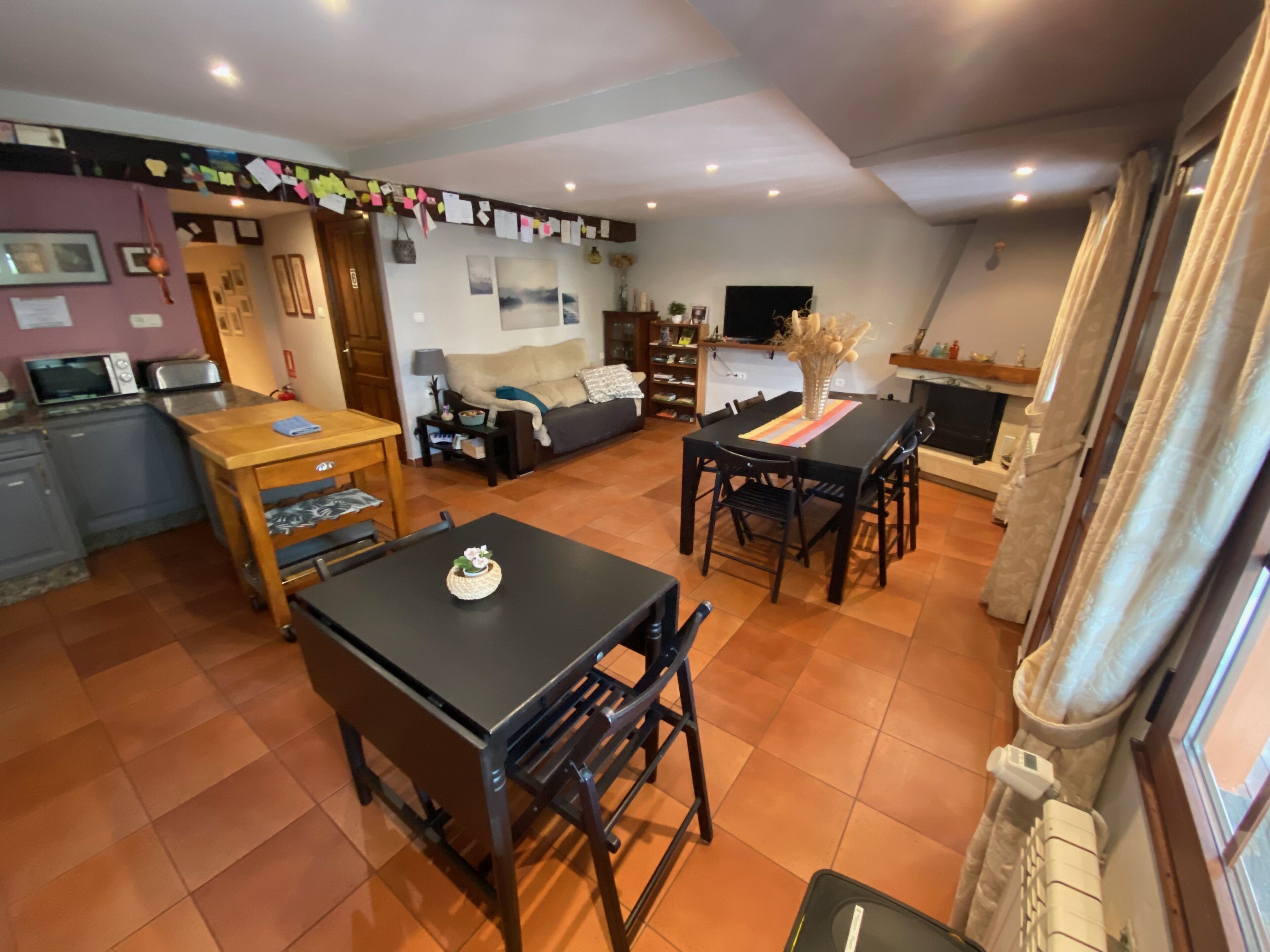 Un'ampia zona giorno con tavolo da pranzo, divano e angolo cottura.