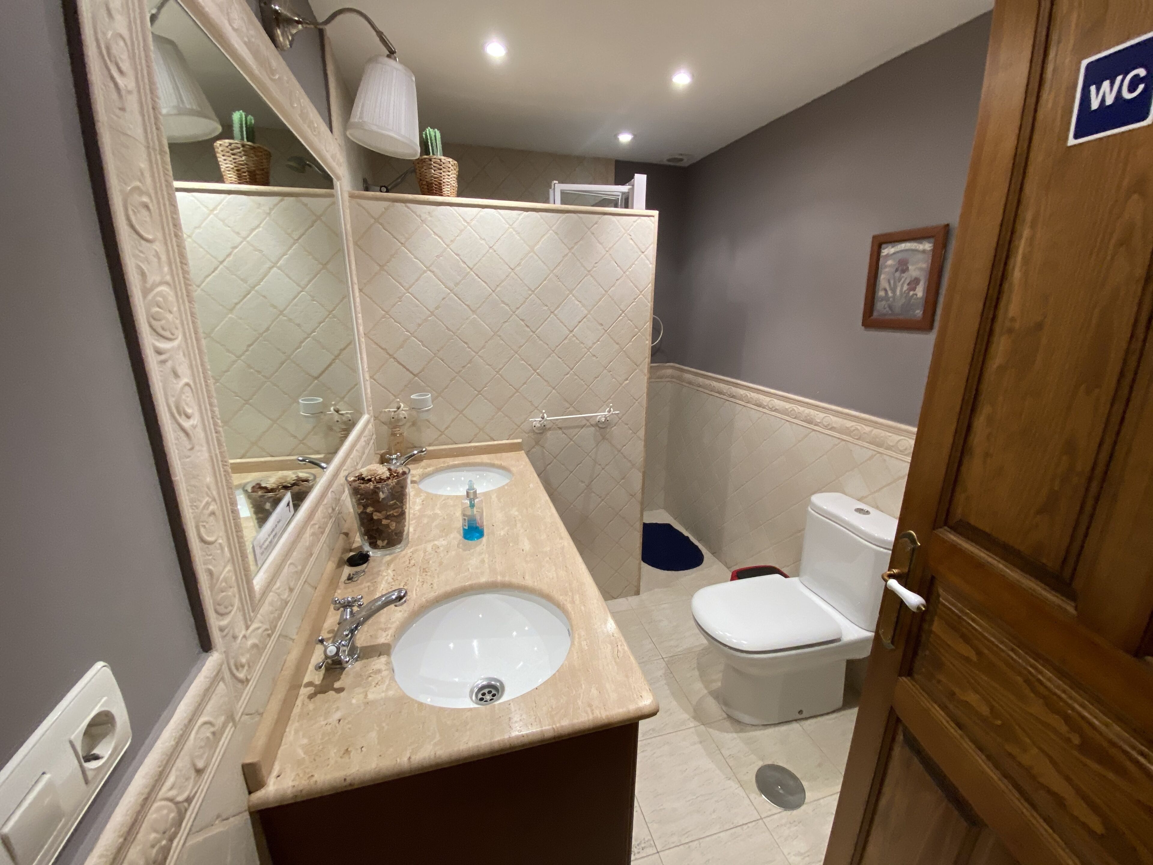 Un bagno con lavandino, specchio e WC.