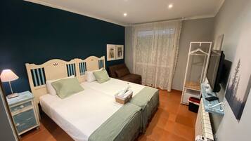 Un dormitorio con dos camas, una mesita de noche, un aparador, un televisor y una ventana con cortinas.