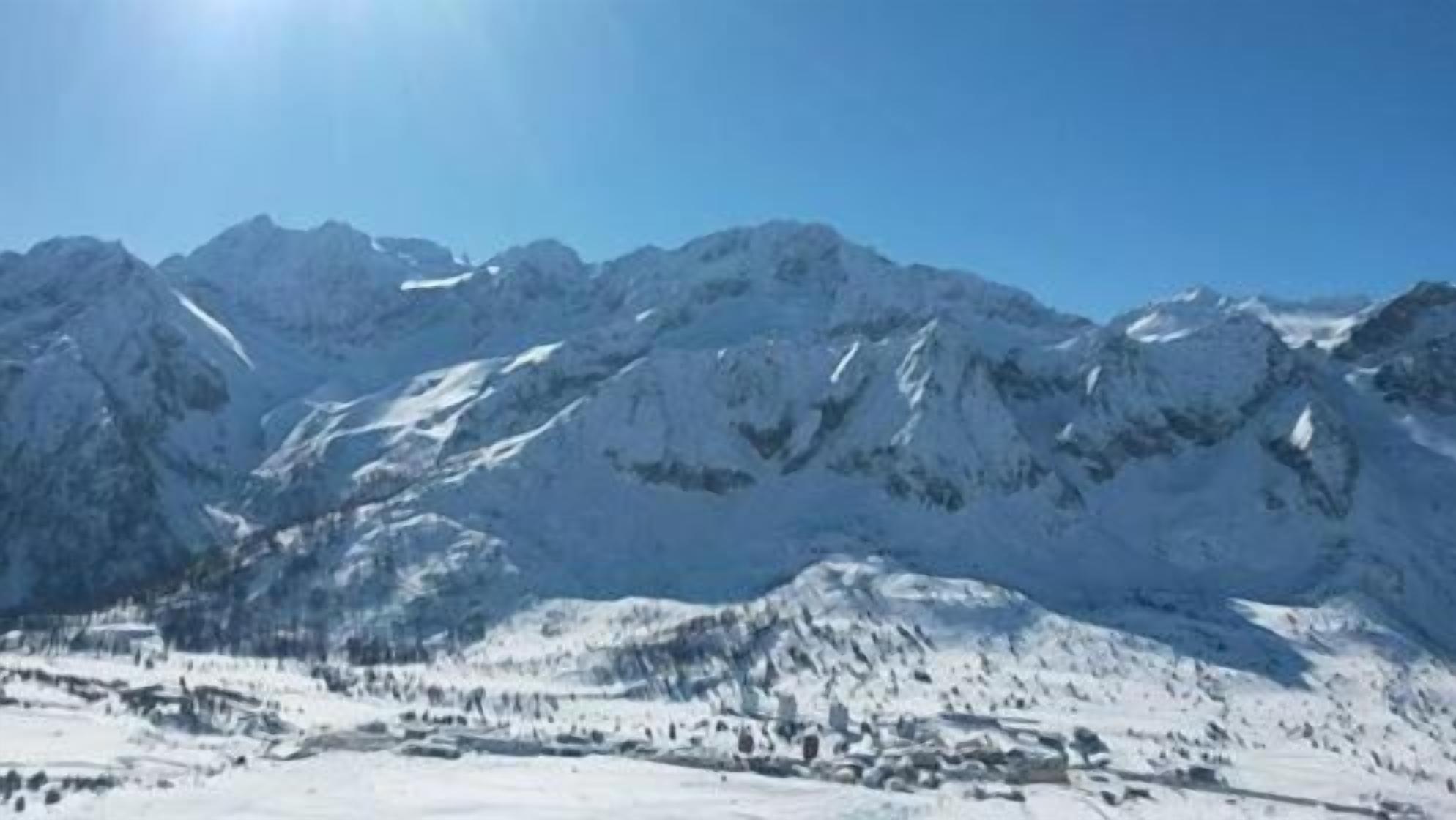 A snow-covered mountain landscape with a clear sky.