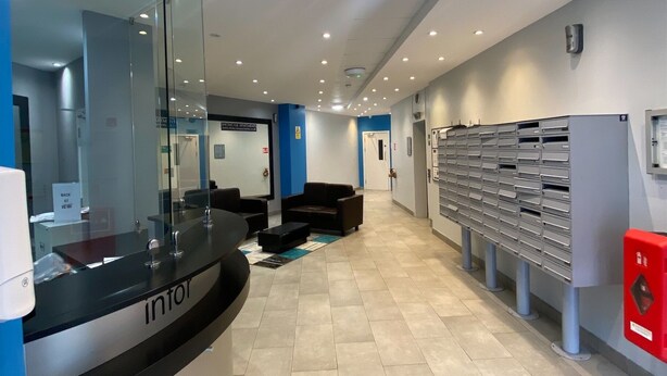 A reception area with a counter, seating, and a mail drop. - Showcase Apartments Kimberley House (Leicester)