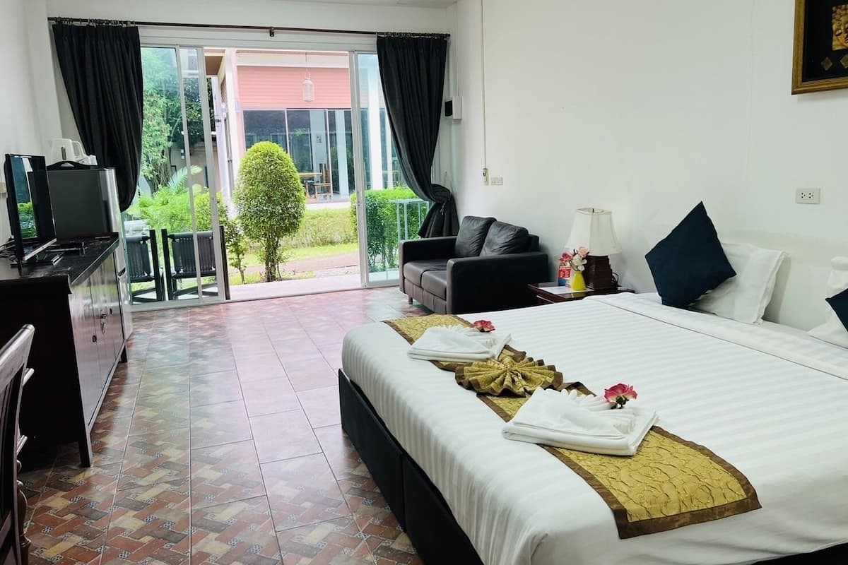 A hotel room with a bed, a desk, a television, and a view of the outdoors.