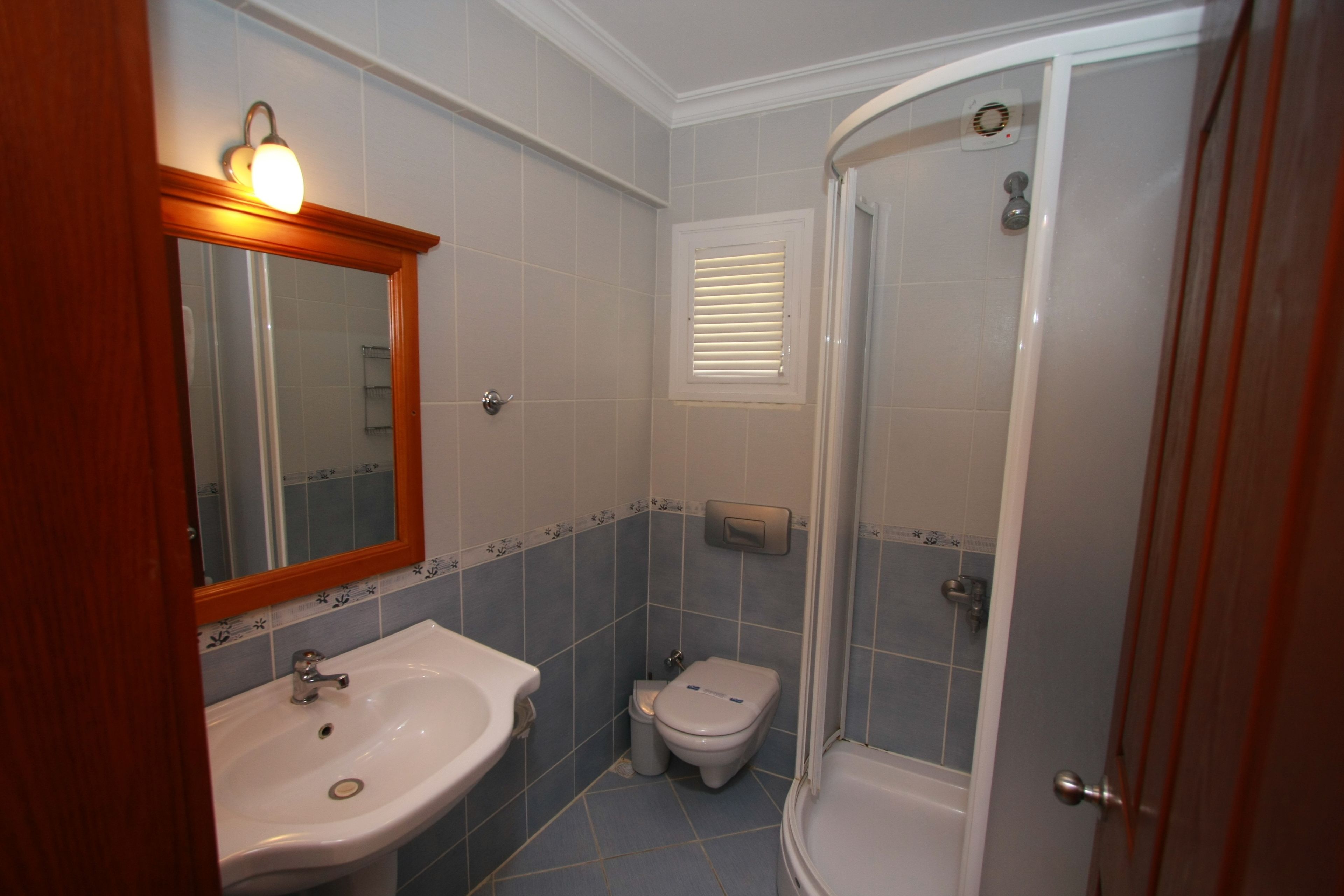 A bathroom with a sink, toilet, and shower.