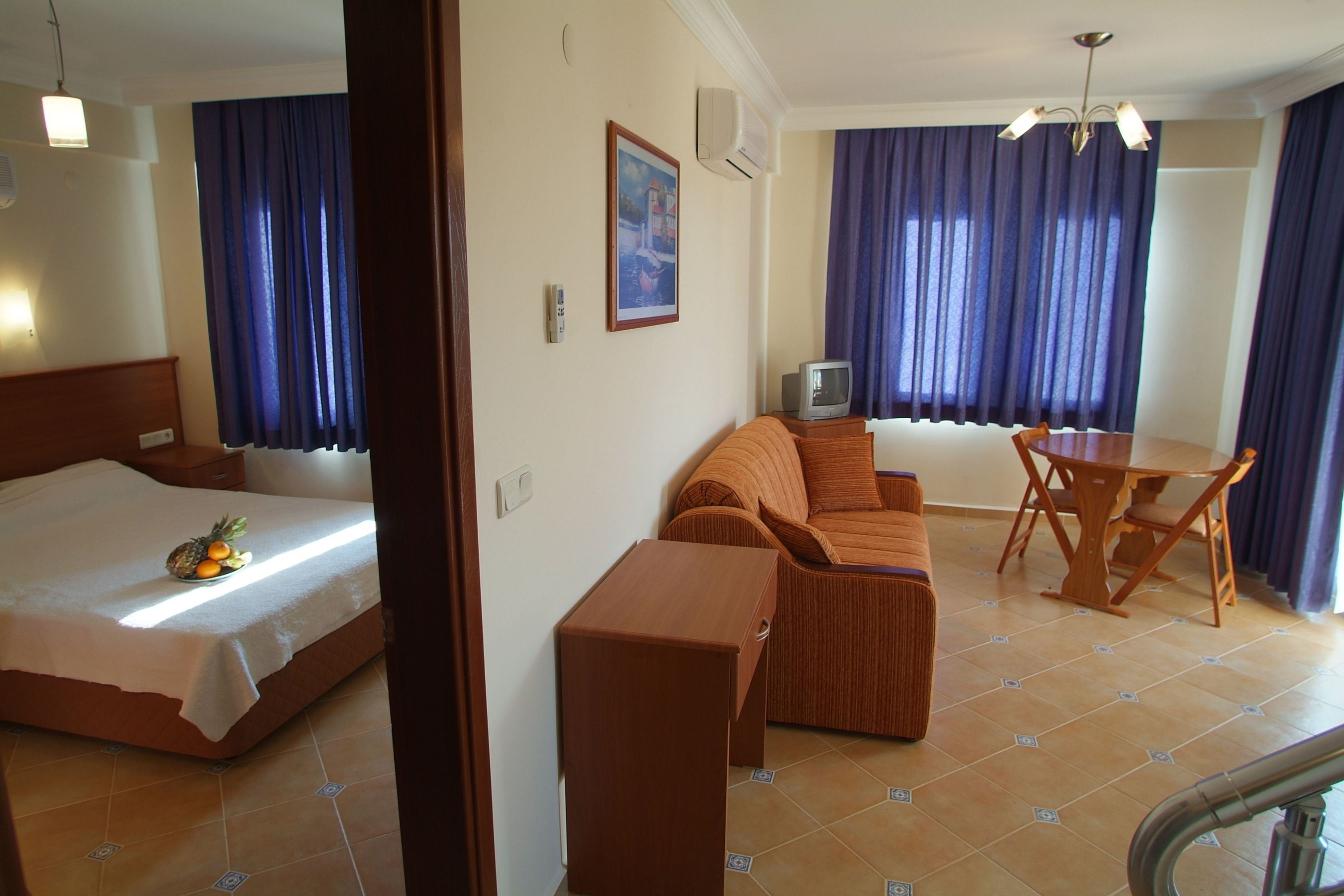 Une chambre d’hôtel avec un lit, un canapé, une petite table et un téléviseur.