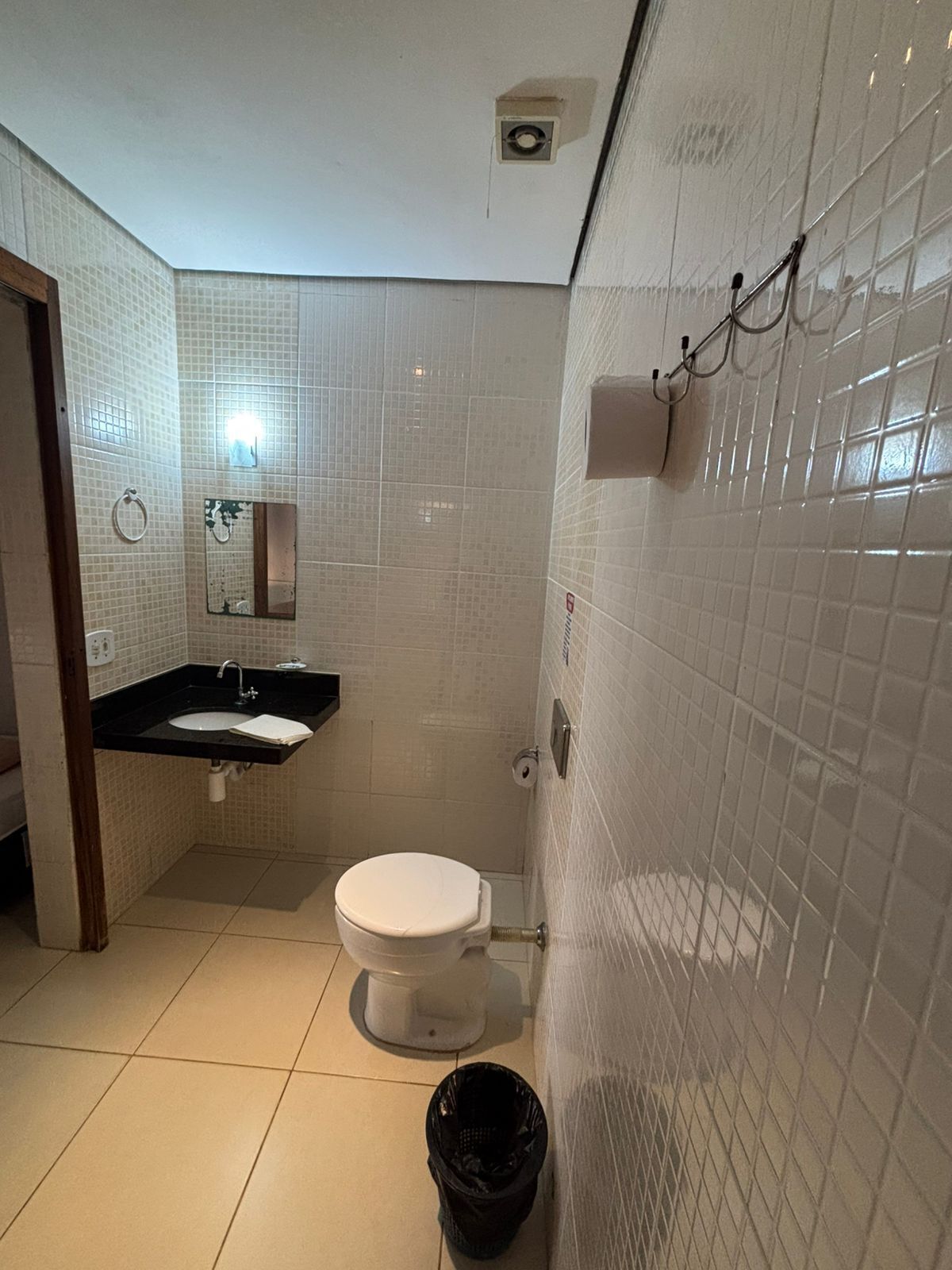 A small bathroom with a toilet, sink, and mirror.