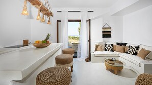Una cocina moderna con encimera blanca, taburetes de madera y una lámpara colgante.