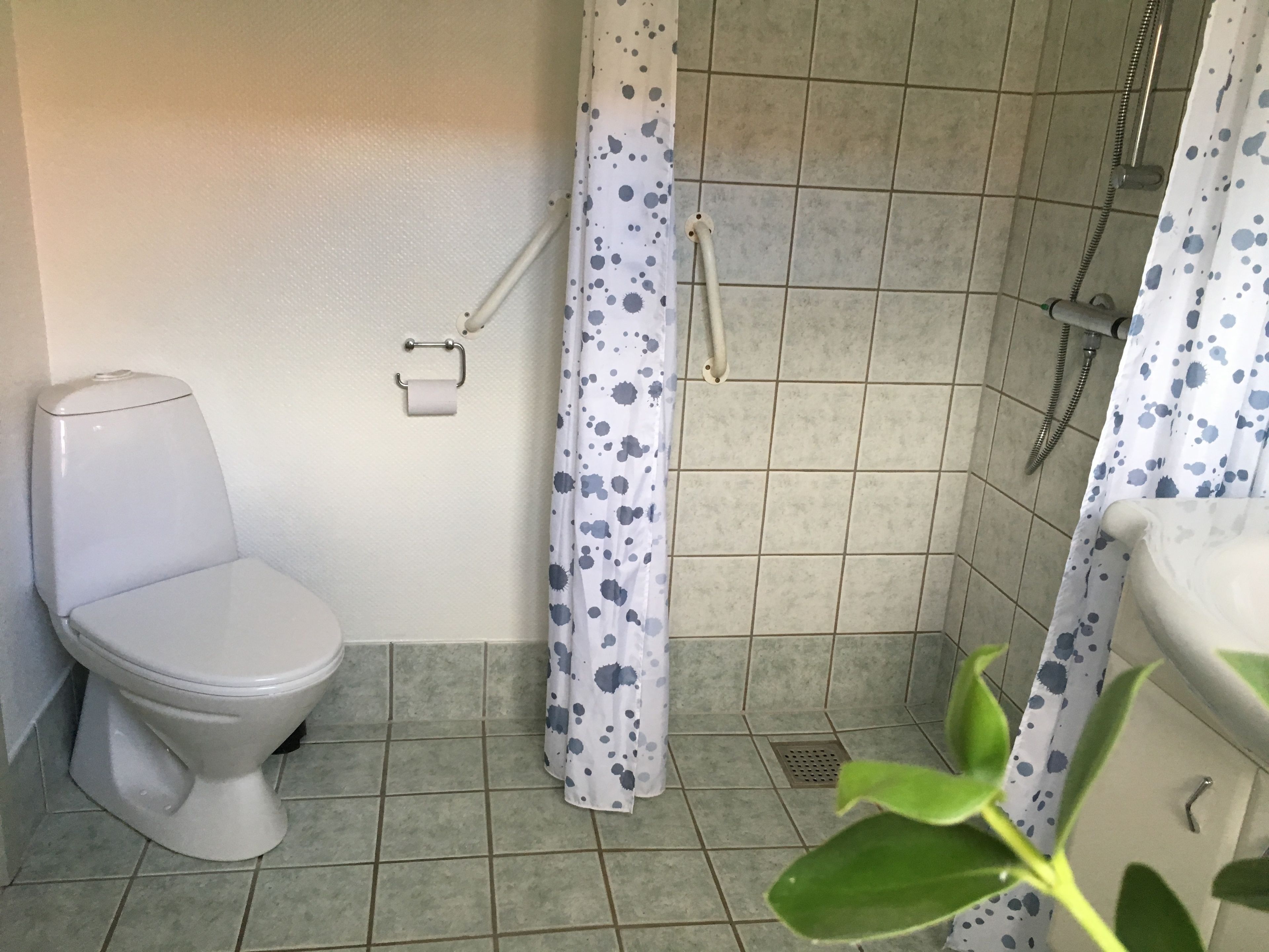 Un baño con inodoro, ducha y lavamanos.