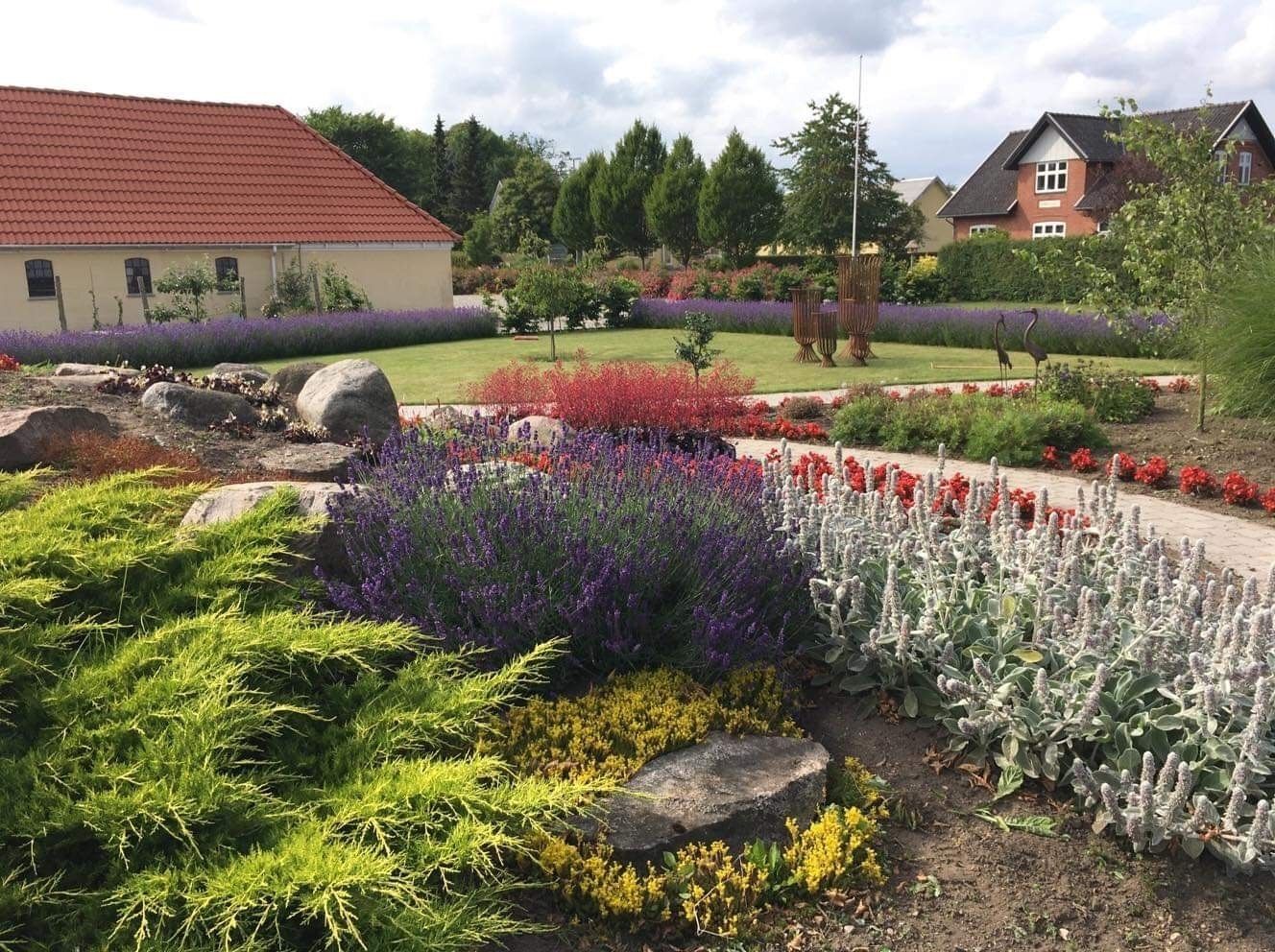 A landscaped garden with various plants and a pathway.