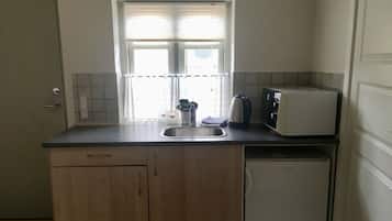 Eine kleine Küche mit Spüle, Toaster und kleinem Kühlschrank.
