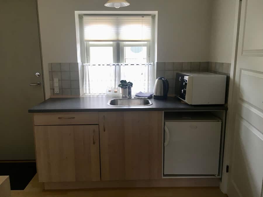 Eine kleine Küche mit Spüle, Toaster und kleinem Kühlschrank.