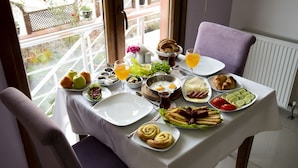 A breakfast table with various food items and a glass of orange juice. - Defne Hotel (Sile)
