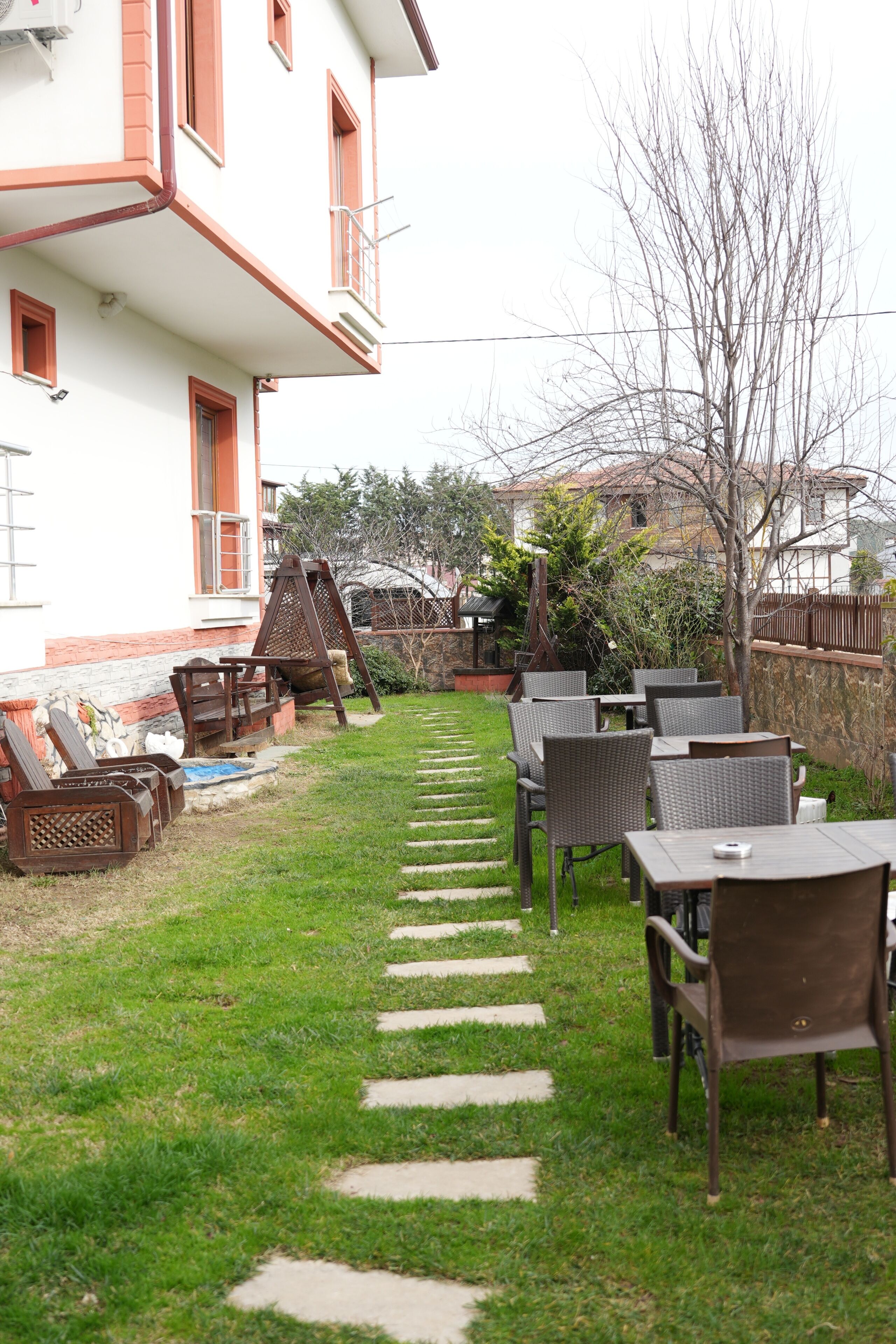 A courtyard with outdoor seating, a stone pathway, and a building with balconies.