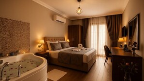 A hotel room with a large bed, a sitting area, a desk, a vanity, and a bathtub. - Defne Hotel (Sile)