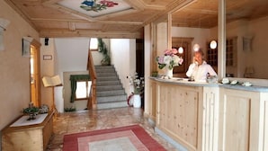 A wooden interior with a staircase, a reception desk, and a mirror. - Meuble Cima Bianca Garni (Bormio)