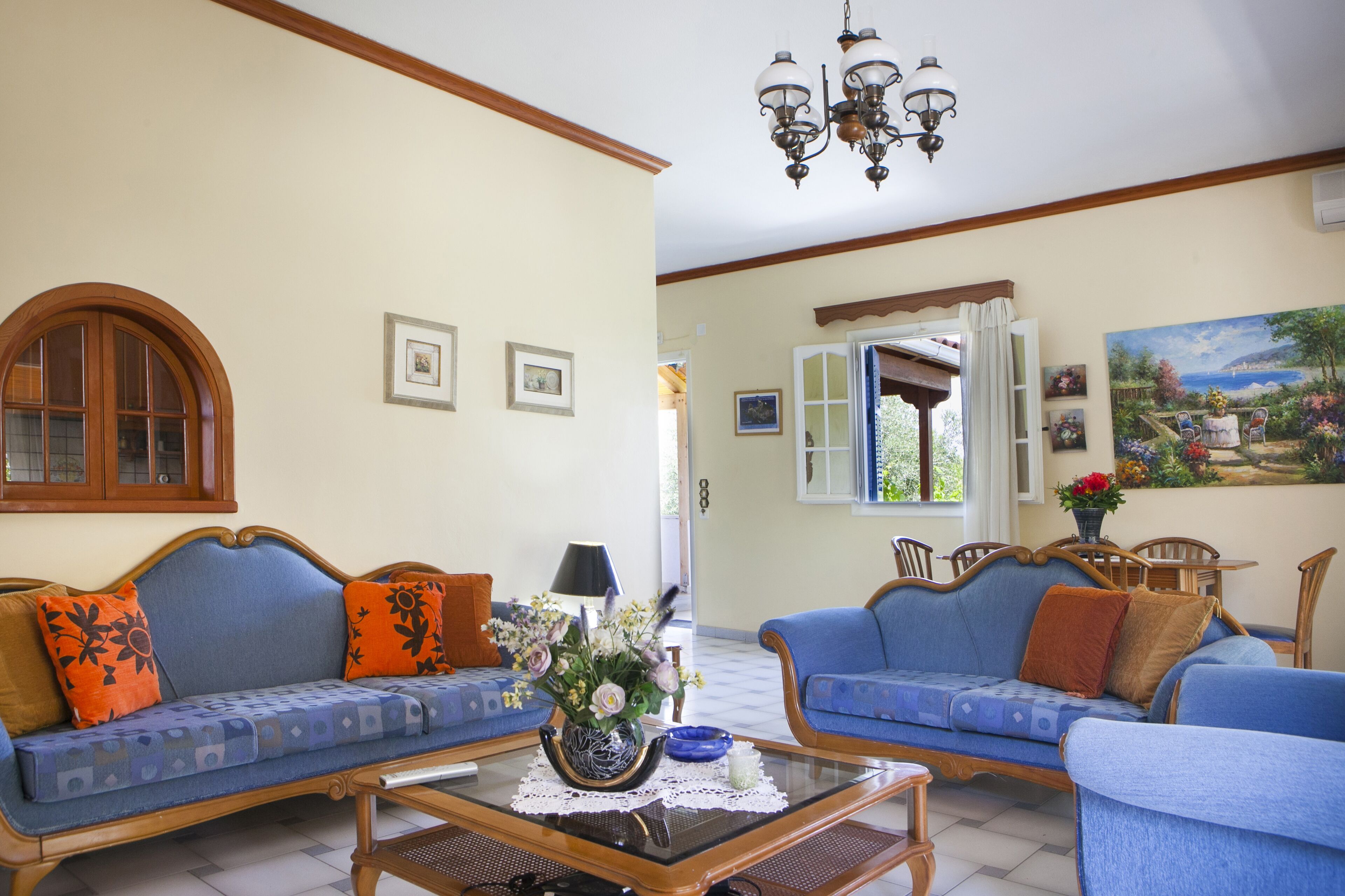 A living room with two sofas, a coffee table, and a dining area with chairs and a table.
