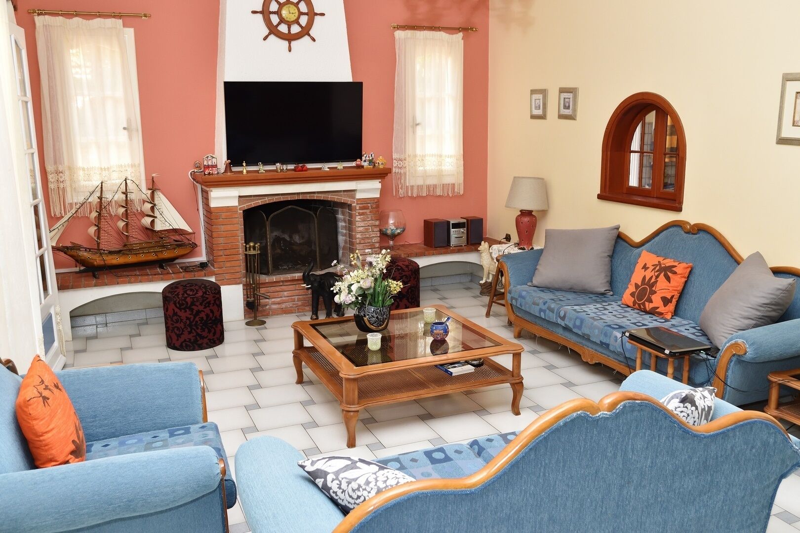 A living room with a fireplace, a television, and blue furniture.