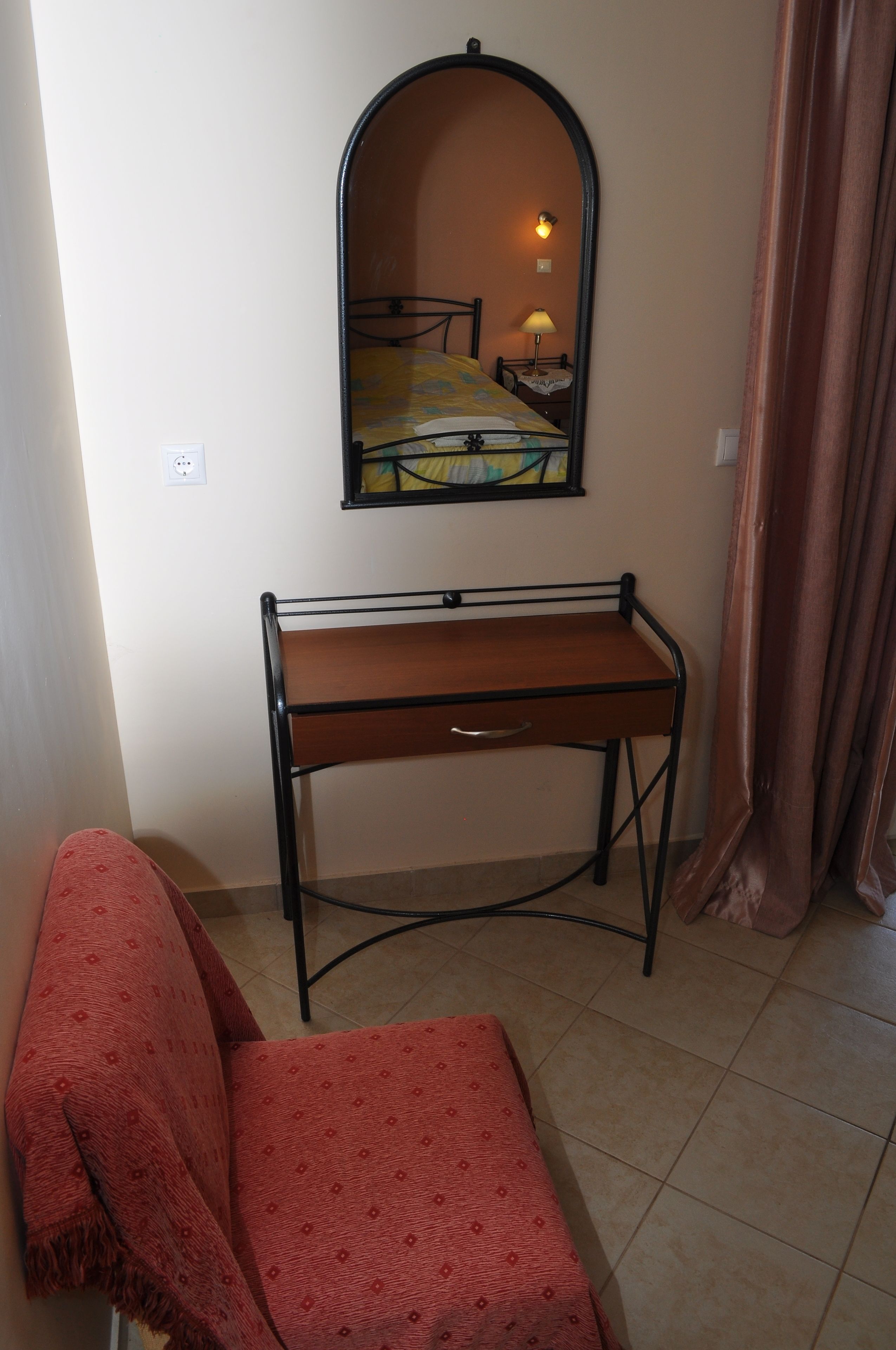 Une pièce comprenant un lit, un bureau, une chaise, un miroir et une lampe.