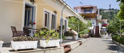 Une rue bordée d’immeubles, avec des terrasses et des plantes en pot.